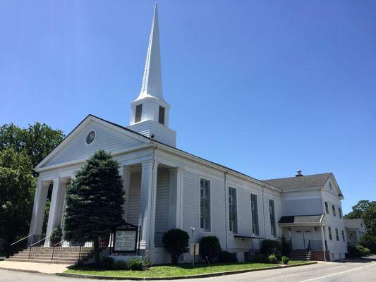 Front diagonal view of New Dorp Moravian Church on a clear sunny day.