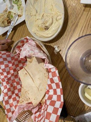 hummus and pita. background is part of shawarma sandwich