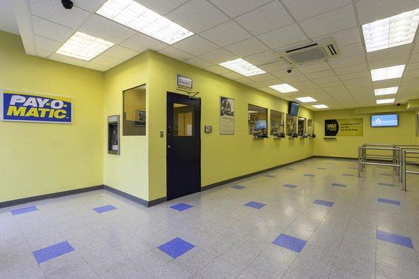 Customer waiting area and teller windows inside PAYOMATIC store located at 11 East Gunhill Road Bronx, NY 10467