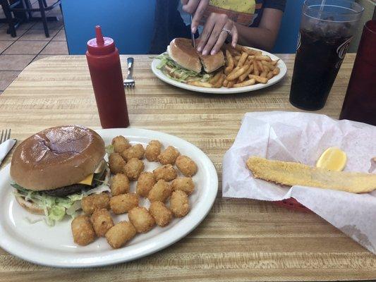 Two cheeseburger combos, one with tator tots, and tea, the other with fries and Dr. Pepper. Side of fried catfish fillet.