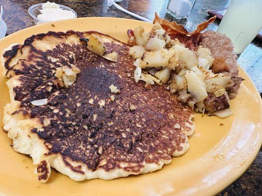 Giant pancake with side of potatoes, sausage patty and bacon!