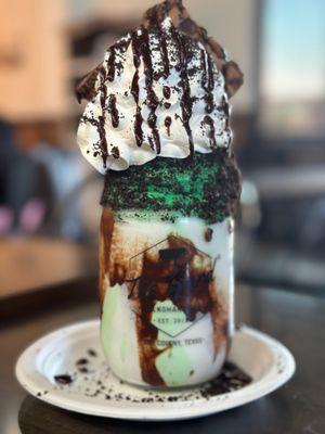 Mint ice cream milkshake with whipped cream and a brownie