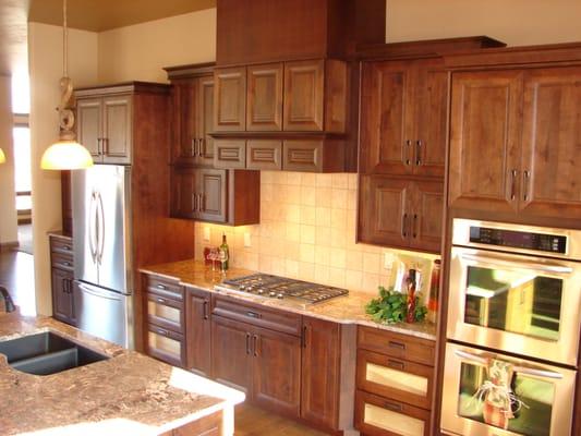 Rich color embraces the Tuscan style.  Knotty Alder stained kitchen with beautiful and functional storage.