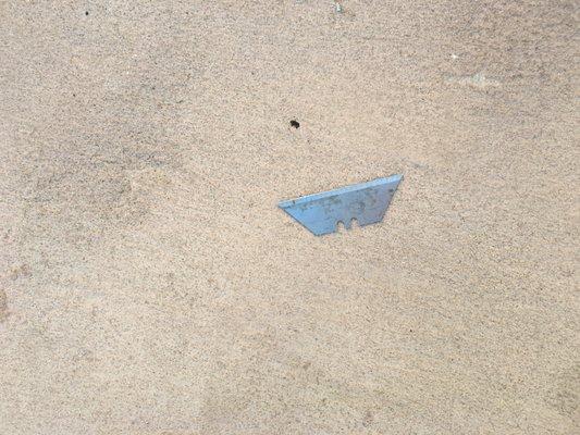 One of two razor blades left by "contractors" on the concrete in front of my door.