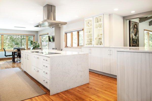 This transitional bright south Tulsa kitchen features a cooking centric island housing an induction cooktop and professional stainless vent.