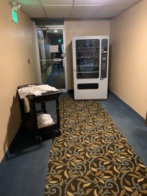 empty vending machine and cart stored in hallway near lobby all weekend