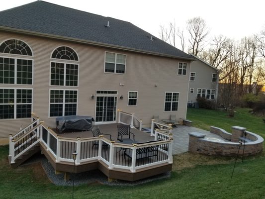 Azek Deck Boards, Vinyl Railings with Black Balusters Plus Lighted post Caps and the Drink Rail Option. In Addition too a Small Patio.