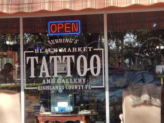 Front of the building. A big glass window that you can see into the tattoo salon