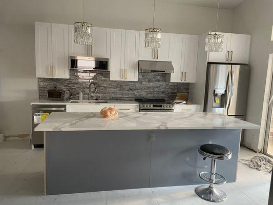 Calacatta quartz eased edge with glass backsplash.