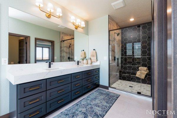 Master Bath with quartz countertops, free-standing tub, tiled shower, black faucets, his and hers walk-in closets