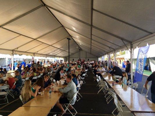 Inside the big tent. Lots of tables and chairs to sit at and enjoy some delicious food.