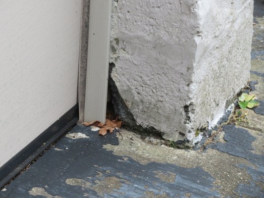 Deteriorated concrete at base of garage.