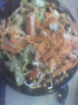 grilled chicken south west salad black beans corn crispy corn tortilla strips lime wedge iceberg lettuce 2 different cheeses.