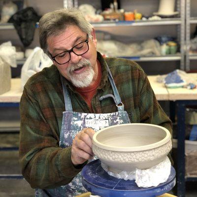 Jim adding texture to a wheel thrown bowl.