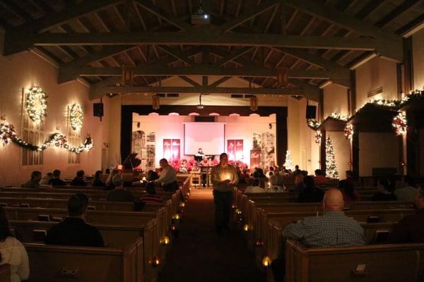 Ushers light candles during the Christmas Eve candlelight service.