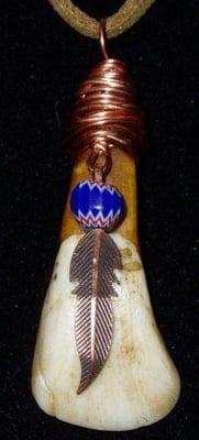 Pendant - wrapped buffalo tooth with copper feathers and old trade bead.  We also sell unfinished, drilled buffalo teeth.