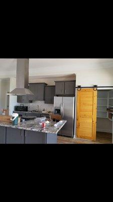 New kitchen, prepped, primed, and painted walls, ceiling, and trim with stained and sealed barn door