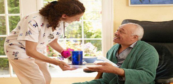 Caregiver giving client breakfast