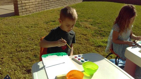 One of the preschoolers creating a masterpiece outside.