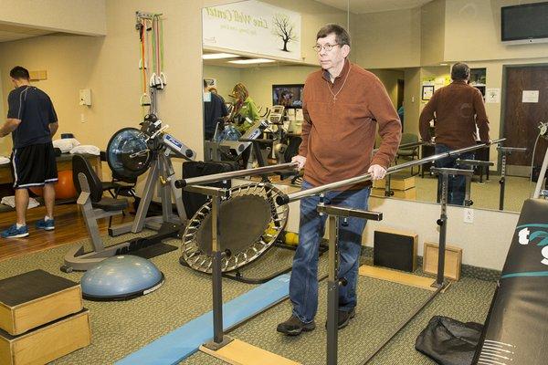 Don Teater using the parallel bars for balance.