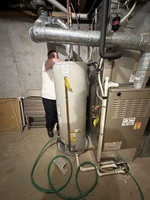 All around plumbing technician fixing leak above water heater in Derby Kansas