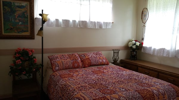 Bedroom w/ queen bed at Dolphin oceanfront cottage in Kehena Beach, Hawaii