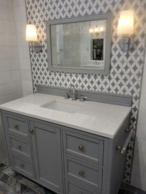 Custom tile on floor and walls, custom bathroom vanity and lighting