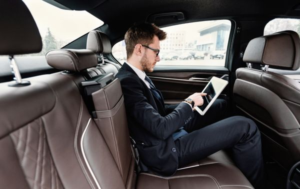 businessman using his laptop on a rochester luxury car service