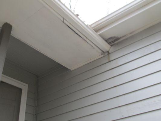 Gutter separating from soffit, soffit damage with water stains.  Evidence of debris and standing water in gutter.  Leak stains on siding.