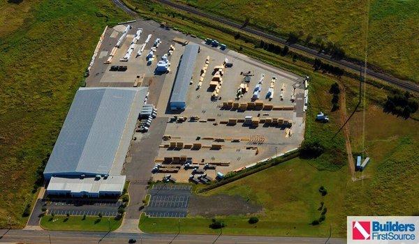 Building materials supplier Builders FirstSource's forklift is moving wood roof trusses.