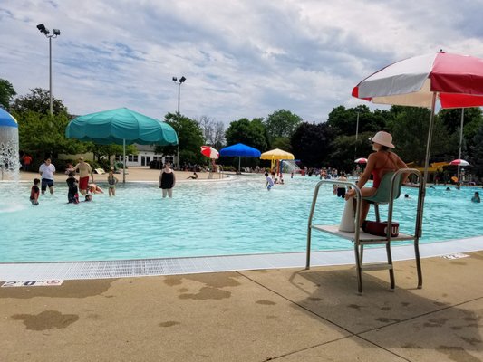 Umbrellas spread throughout the shallow areas provide shade, lifeguards keep a close eye on things.