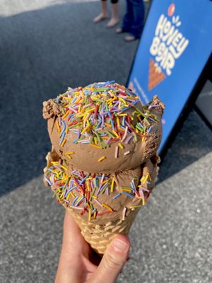 Double scoop of vegan black star (chocolate w/ brownie) in a gf waffle cone w/ rainbow sprinkles