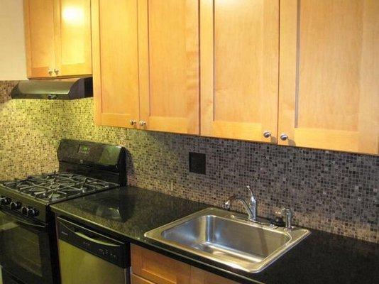 Kitchen renovation with cabinets from Stock Cabinet Express. Counters from Home Depot (Absolute Black granite). Custom marble backsplash.