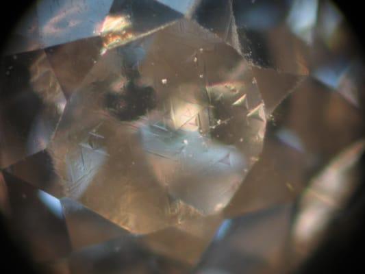 Triangle shaped markings on a diamond are a sure indication that it is natural in origin. It is rare to see them on the main table facet.