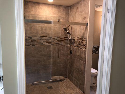 Tile shower & installed glass shower door.