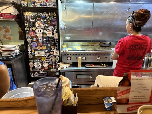 At the counter watching them cook