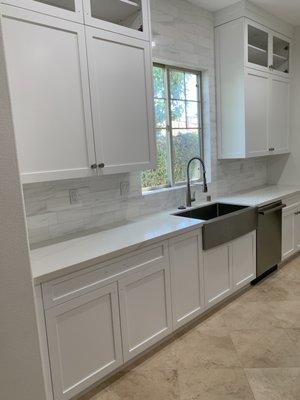 Backsplash to ceiling with custom cabinetry in white shaker and Emtek hardware.