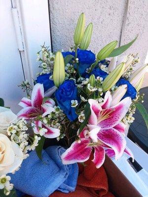 My bridal bouquet (blue roses & starfire lilies )  with a glimpse of the all-white bouquet for the Virgin Mary