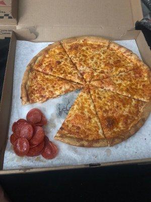 A cheese pizza with uncooked pepperoni's added to make it a "pepperoni" pizza.