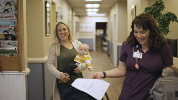 Nurse assisting mother and baby