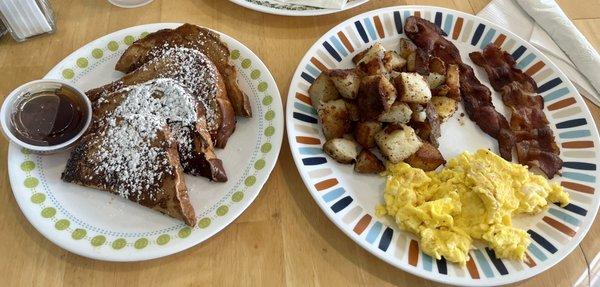 French toast with fried potatoes, scrambled eggs, and bacon.