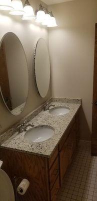 Bathroom vanity, lights, mirror, painting and custom countertop.