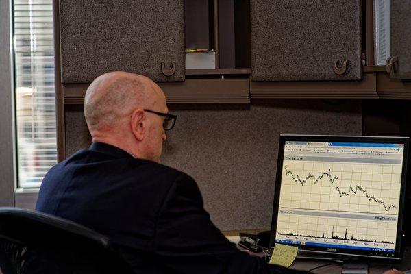 Photograph of Joe doing investment research. He has over 20 years of financial experience.