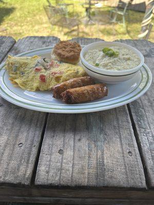 Brunch Omelet with sausage links, creamy grits, and biscuit.