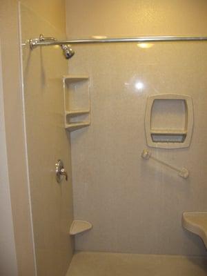 Tub converted to a walk in shower with seat and grab bar.