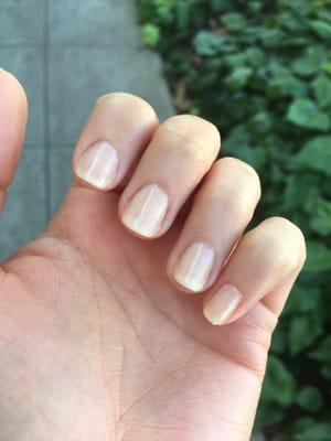 Jagged edges of nails were not filed down (see pinky) and cuticles were not completely cleared from nail before polishing. Uneven polish.