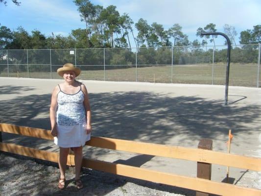 Scruffy person in front of hoopless hoop court