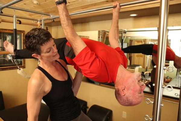 A 65-year-old client expanding his skills doing 'Upside-Down Pull-Ups