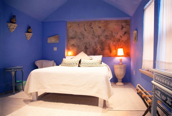 The Greek room is a temple of beauty and serenity featuring an organic queen bed and spa tub room with chroma-therapy.