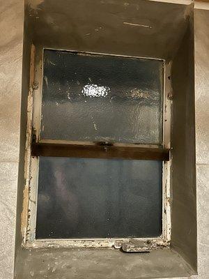 The window in the shower in the bathroom.